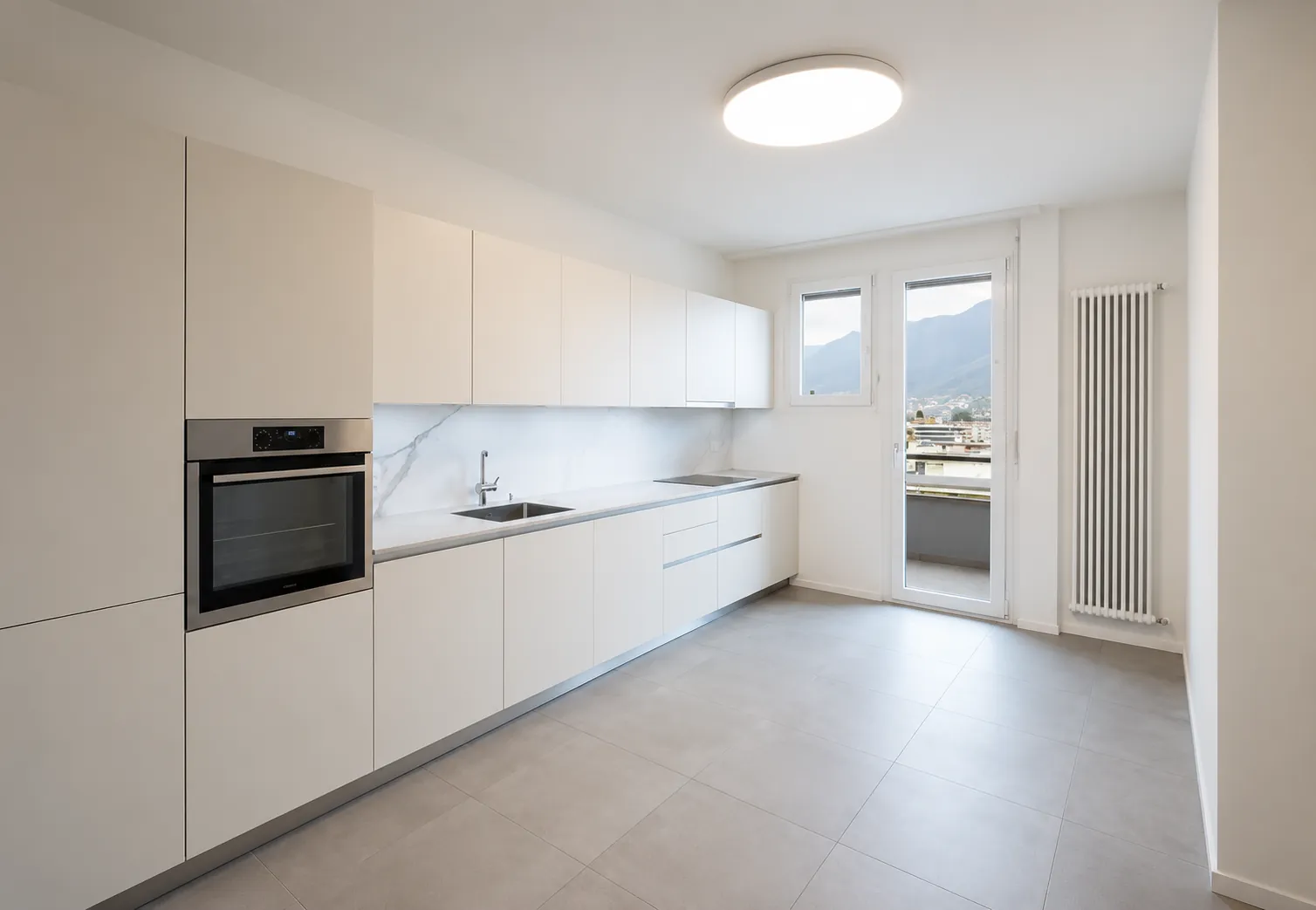 Attico Besso 1856 - cucina abitabile con accesso al balcone e vista sulle montagne